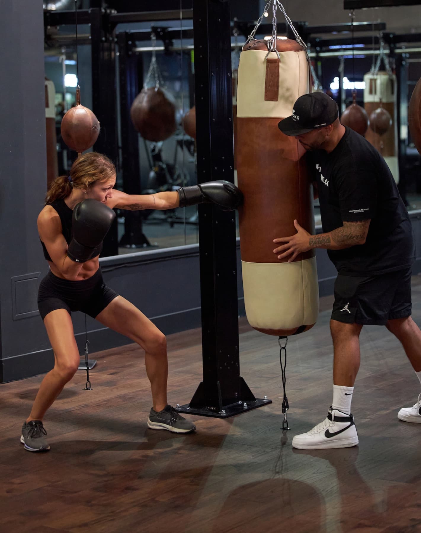 Coach holding the heavy bag for a client